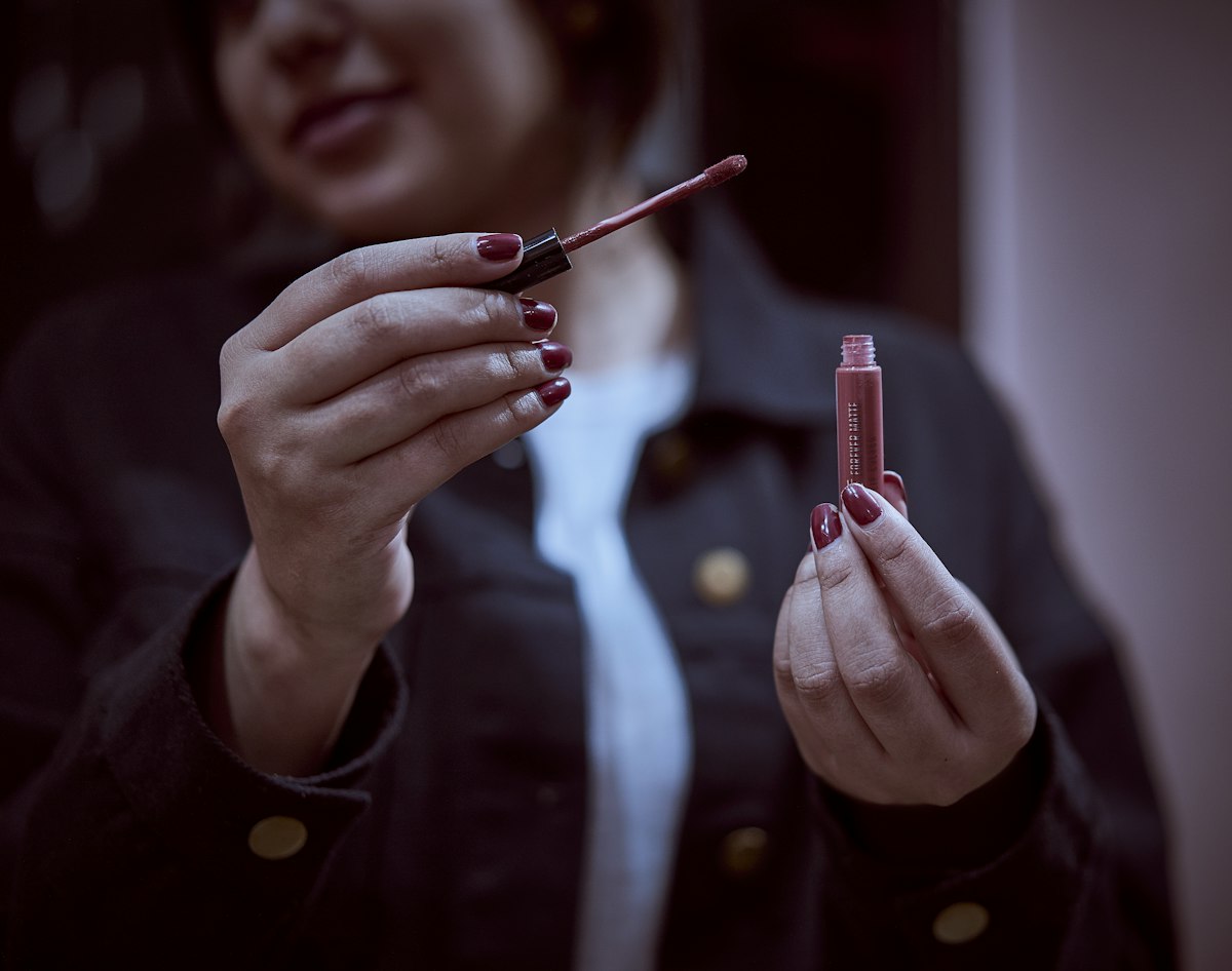 person holding red pen and writing on paper